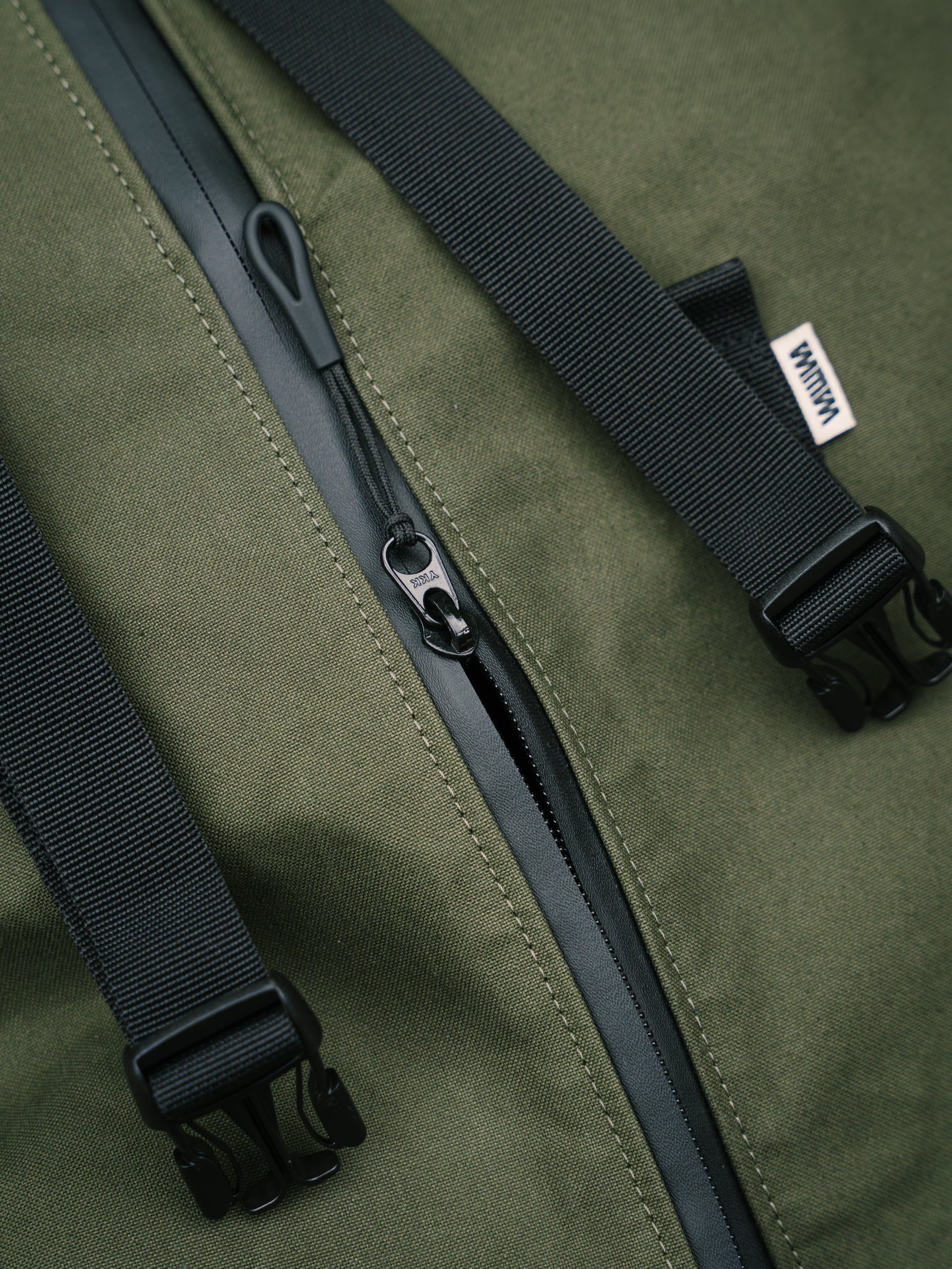 Waterproof zip and strap detail on the Bridge Backpack in Khaki Green